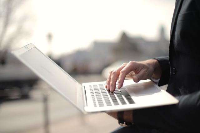person on a laptop in an outdoor setting